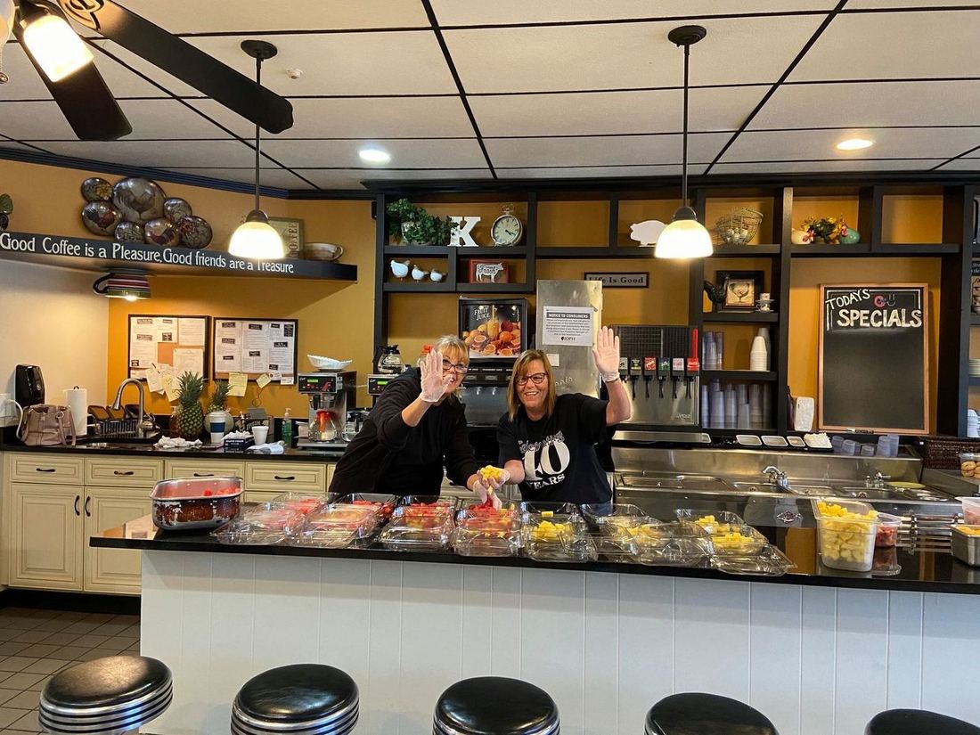 The team waving behind the counter